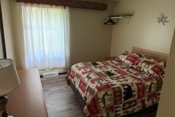 Cozy bedroom with bear-themed bedding and wooden furniture.