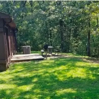 a large green field with trees in the background