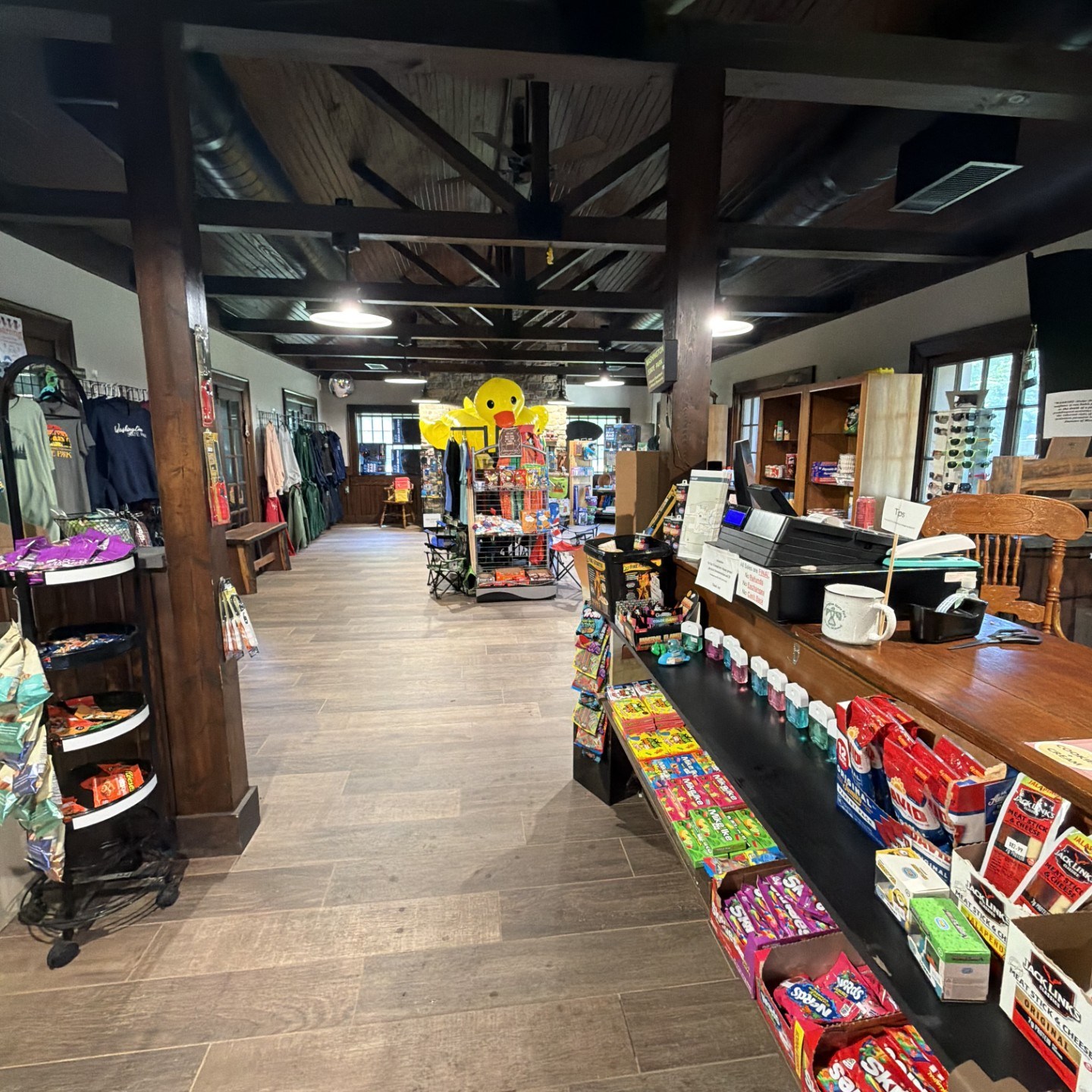 Interior of a store with clothes, snacks, and a checkout counter.